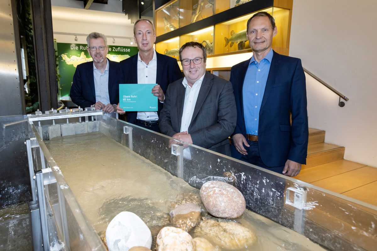  Bernd Heinz, Vorsitzender der AWWR, NRW-Umweltminister Oliver Krischer, Prof. Christoph Donner, Vorstandsvorsitzender des Ruhrverbands und Christoph Gerbersmann, Finanzvorstand desRuhrverbands, am Fließgewässermodell im Haus Ruhrnatur anlässlich der Vorstellung des Ruhrgüteberichts für das Berichtsjahr 2025.